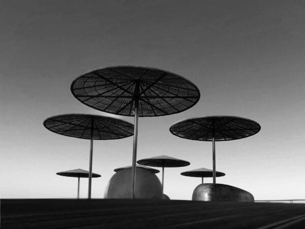 Black and white photo of umbrellas on a pier