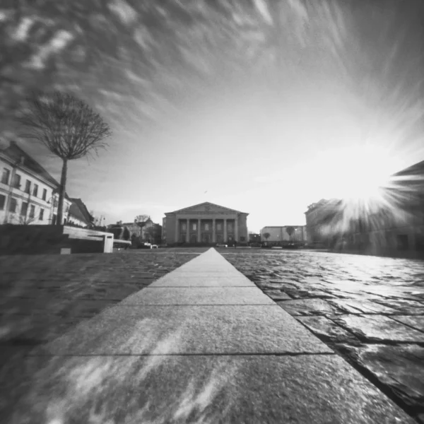 Black and white photo of a street with a distant building