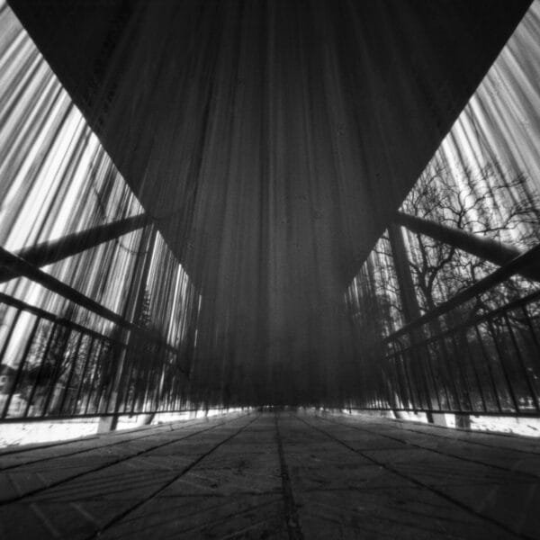 A monochrome image of a bridge adorned with a curtain